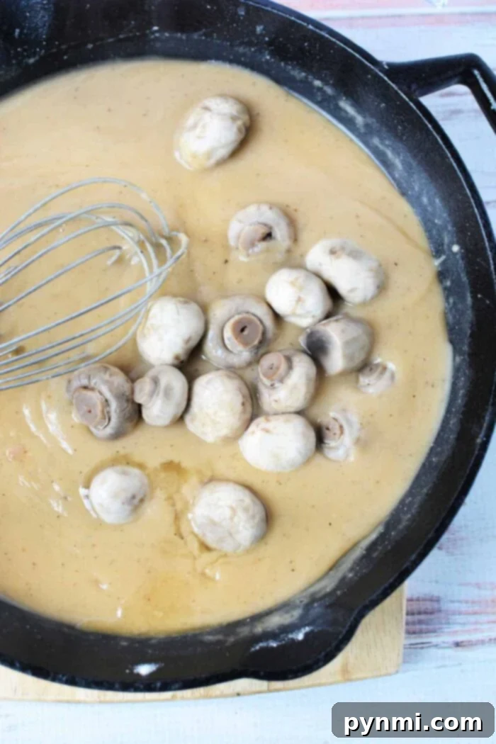 Skillet Pork Chops with Savory Mushroom Gravy 4 Rich and creamy mushroom gravy in a cast iron skillet, ready to be paired with pork