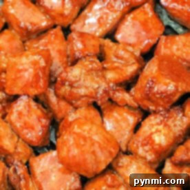 A close-up of seasoned and cooked meat pieces, their glossy reddish-brown coating revealing the secrets of how to cook steak tips in the oven to perfection.