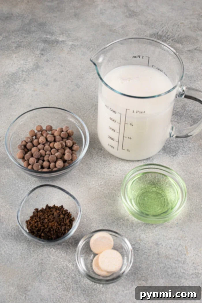 Whip Up Perfect Boba Pearls at Home 3 Ingredients on a table are milk in a measuring cup, chocolate chips, instant coffee, mint oil, and two tablets—a perfect setup to learn how to cook boba for bubble tea.