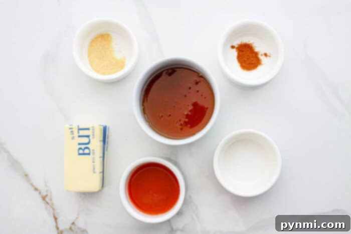 Sweet Heat Perfection: Crafting Homemade Hot Honey 3 A selection of ingredients laid out, including honey, hot sauce, butter, salt, and garlic powder, ready to make hot honey.