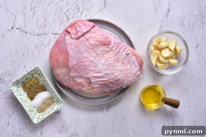 Mastering Turkey Breast Confit 3 A raw turkey breast on a plate is placed on a kitchen countertop. Surrounding it are a small dish of spices, including salt and pepper, a bowl with peeled garlic cloves, and a small container of olive oil—perfect ingredients for preparing Turkey Confit.