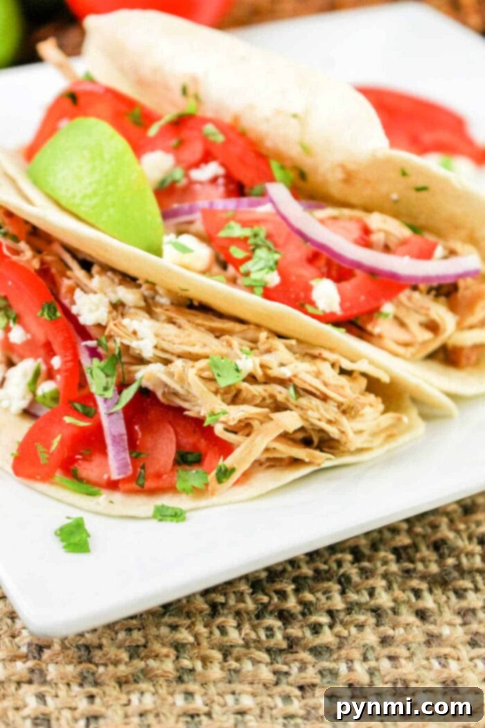 Zesty Green Chili Slow Cooker Chicken 8 Delicious green chile chicken tacos, garnished with cilantro and lime.