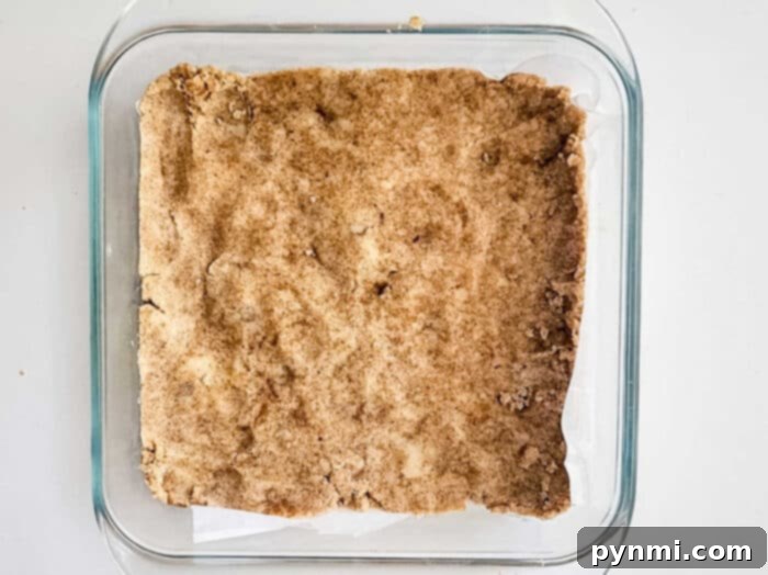 Golden shortbread crust in a baking pan, ready for a delicious fruit filling.