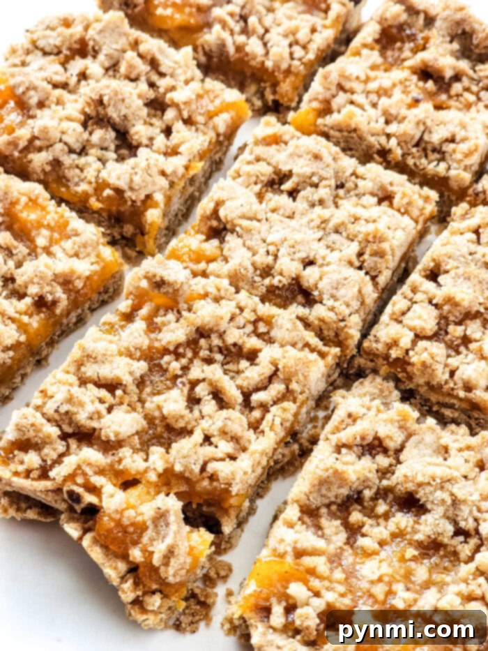 Close-up of beautiful Peach Bars with Canned Peaches, showing the crumbly topping and the soft fruit filling, ready to be enjoyed.