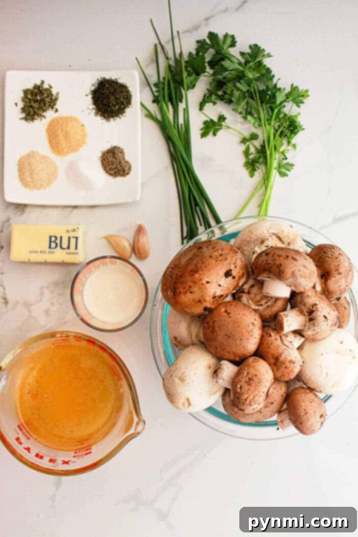 Ingredients for crockpot mushrooms: mushrooms, herbs, butter, garlic, cream, broth, parsley, and chives on a marble surface.