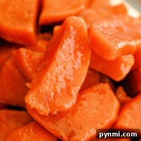 Close-up of slow cooker candied sweet potato slices with a glossy, caramelized finish.