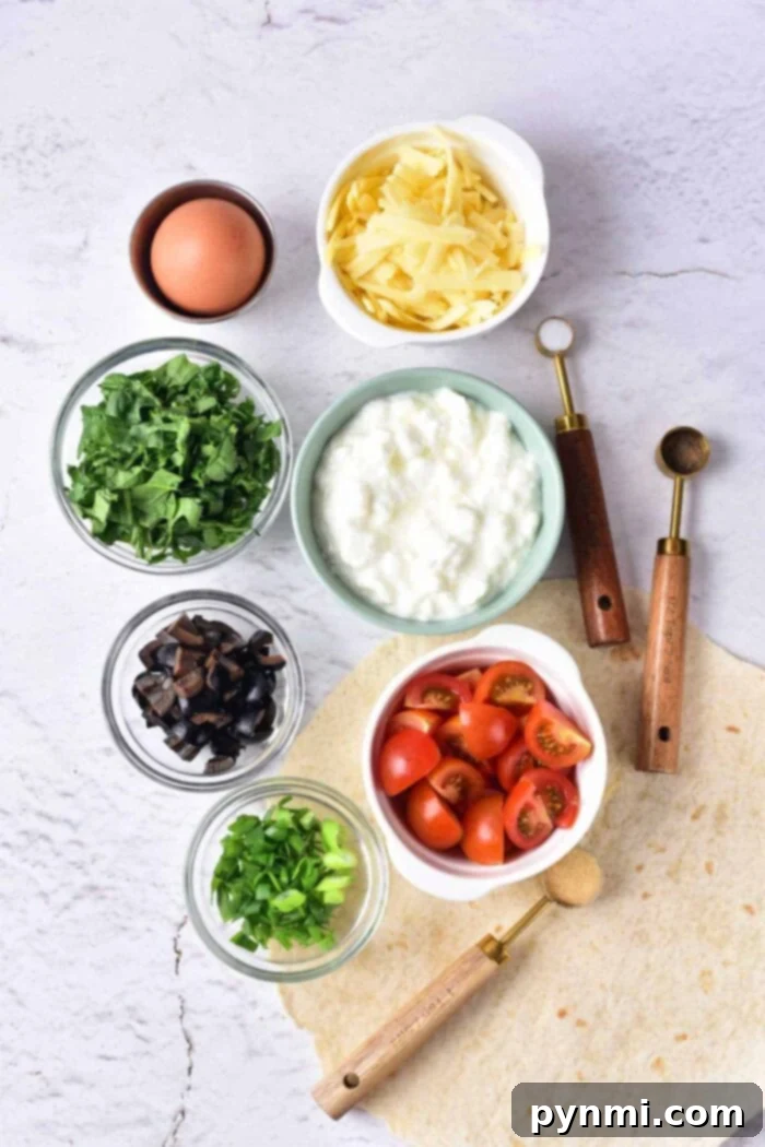 Light and Creamy Cottage Cheese Quiche 3 A flat lay image showcases various fresh ingredients essential for making a delicious Cottage Cheese Quiche. These include shredded cheese, a whole egg, fresh spinach leaves, creamy cottage cheese, vibrant cherry tomatoes, sliced mushrooms, chopped green onions, and a large flour tortilla. Two wooden-handled scoops are positioned neatly beside the ingredients, suggesting readiness for cooking.