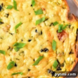 A close-up shot of a golden-brown Cottage Cheese Quiche slice on a pristine white plate. The quiche features a melted cheese topping, studded with tiny bits of colorful vegetables, and is elegantly garnished with freshly chopped green onions. Its crust appears perfectly baked.