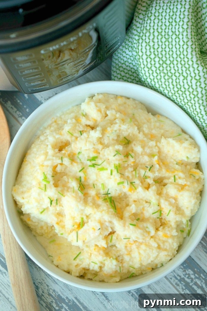 Easy Cheesy Crock Pot Express Grits for Breakfast or Side Dish Deliciously cheesy grits served in a bowl, garnished with fresh chives, ready to eat, made in a Crock Pot Express pressure cooker.