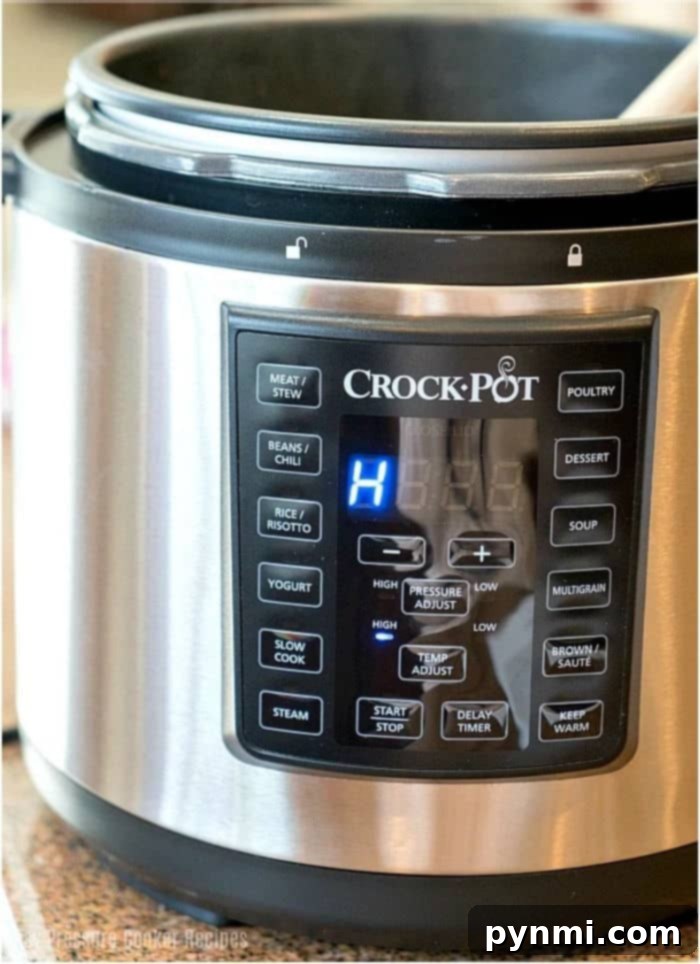 Crock Pot Express for Easy Pressure Cooking An open Crock Pot Express electric pressure cooker on a kitchen counter, showcasing its inner pot and lid.