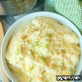 Cheesy Crock Pot Express Grits ready to be served, garnished with fresh herbs