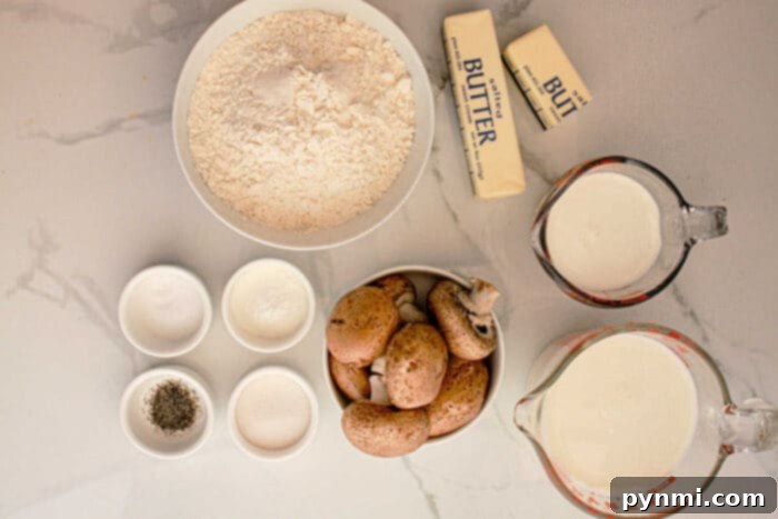 Set-It-and-Forget-It Biscuits and Gravy 3 A collection of essential ingredients for Slow Cooker Biscuits and Gravy laid out on a white marble surface, including flour, butter, milk, cream, whole mushrooms, salt, pepper, and sugar in small bowls, ready for preparation.
