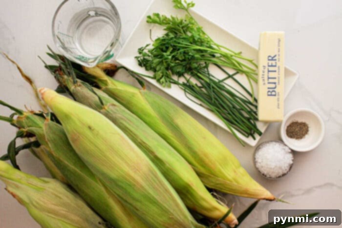 Tender Slow Cooker Corn Perfection 3 An arrangement for Crockpot Corn on the Cob: fresh corn on the cob, a glass of water, a bunch of parsley and chives on a white plate, unsalted butter, and small bowls of salt and pepper on a pristine white surface.