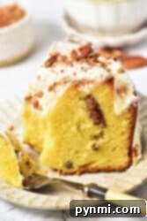 A slice of Sock it to me cake, made with a delightful cake mix, sits on a plate with frosting and nuts, accompanied by a fork.