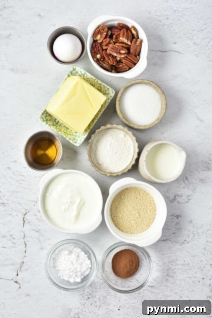 A selection of fresh ingredients neatly arranged on a kitchen counter for an easy Sock It To Me Cake recipe, including eggs, chopped pecans, softened butter, granulated sugar, all-purpose flour, milk, vanilla extract, sour cream, powdered sugar, and ground cinnamon.