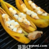 Grilled banana s'mores filled with melted chocolate and toasted marshmallows, ready to be enjoyed as an easy and delicious BBQ dessert.