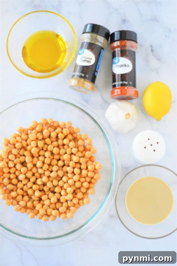 A top-down view of a bowl of freshly made homemade hummus, garnished with a drizzle of olive oil and a sprinkle of paprika.