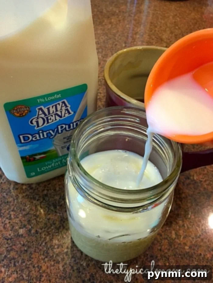 Homemade coffee creamer in two mason jars, vanilla and hazelnut flavors, on a wooden surface