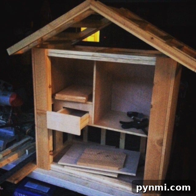 A partially constructed DIY Little Free Library, showcasing the use of reclaimed wood and an old window as the door.