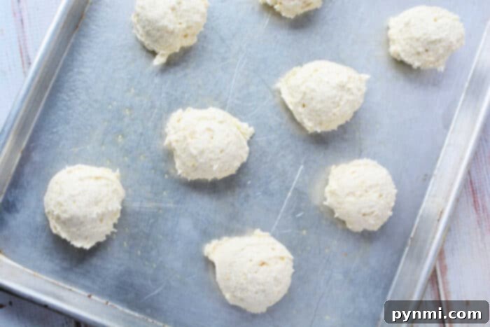 Raw sour cream biscuits dough on a baking sheet, ready to be baked.