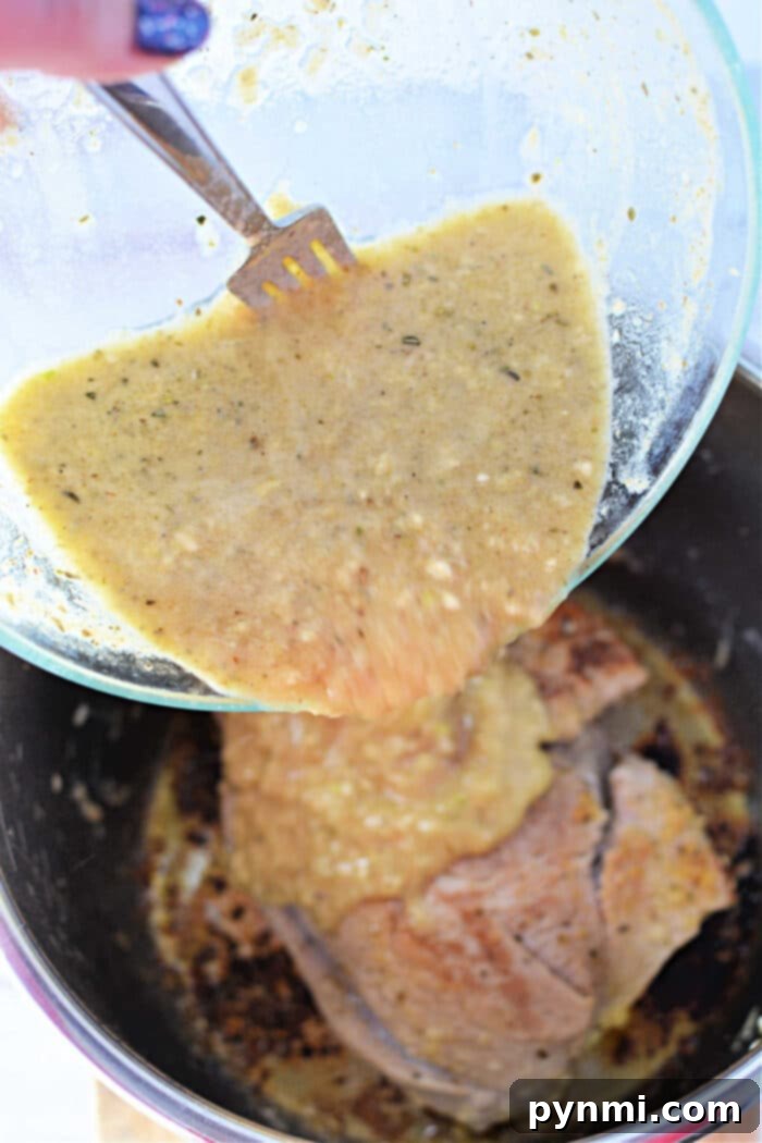 Pouring yellow marinade over pork in a pot, using a fork to scrape from a glass bowl.
