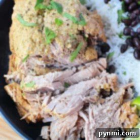 Savor shredded pork with herbs, paired perfectly with white rice and black beans, all garnished with lime wedges on a black plate—an exquisite roast recipe for any culinary enthusiast.