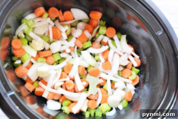 Set It and Forget It Slow Cooker Bone Broth 3 Chopped carrots, celery, onions, and potatoes simmer in a savory broth recipe within the slow cooker.