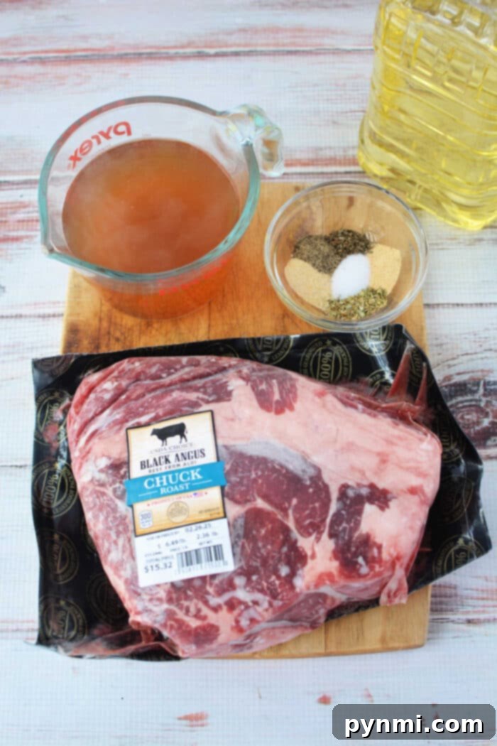 Stovetop Braised Beef 3 Stove Top Pot Roast ingredients: raw chuck roast, spices in a bowl, vegetable oil, and beef broth in a measuring cup all rest invitingly on the wooden surface.