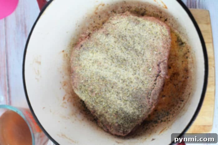 Stovetop Braised Beef 4 A seasoned raw meat roast sits in a pot, poised for cooking into a delicious stove top pot roast.