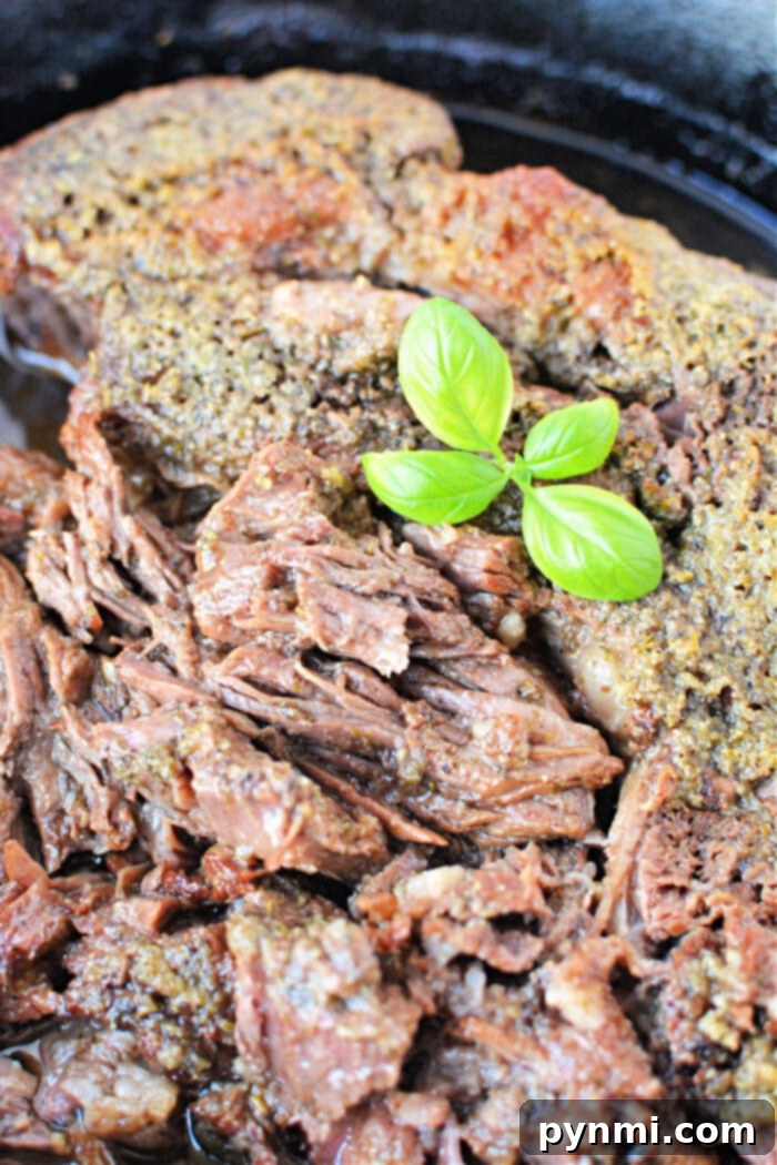 A close-up of perfectly cooked boneless beef topped with fresh green basil leaves.