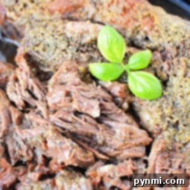 A close-up of perfectly cooked boneless beef topped with fresh green basil leaves.