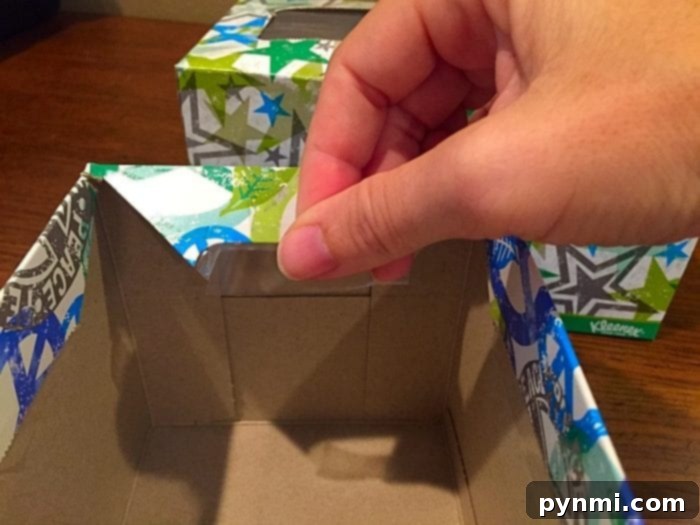 Give Kleenex Boxes a Second Life 7 Illustrative image showing diagonal cuts being made on the corners of an empty Kleenex box for crafting.