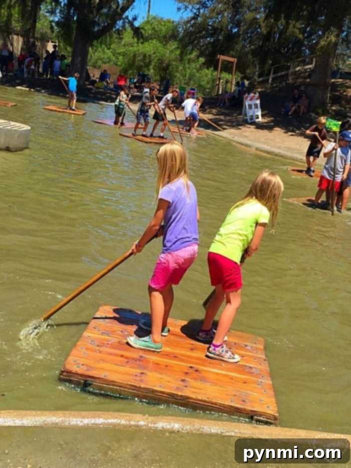 Children happily navigating rafts across the muddy lake at Huntington Beach Adventure Playground.