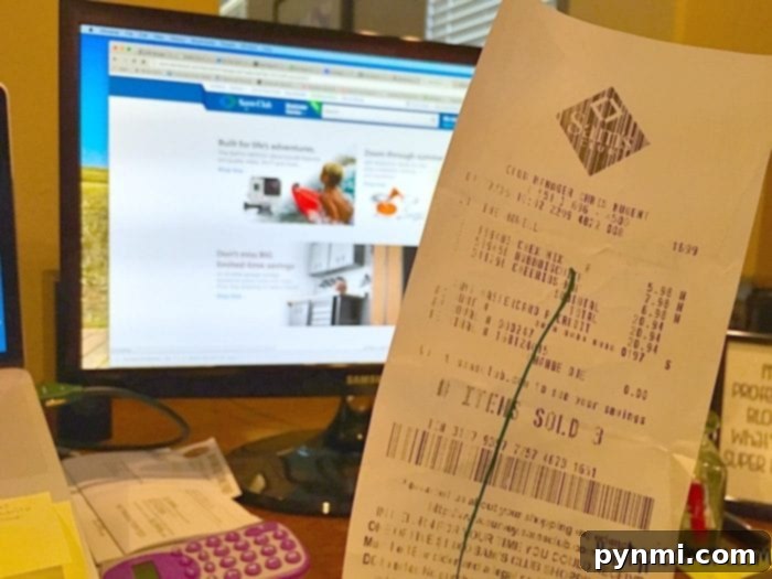 A close-up of a hand holding a receipt and a mobile phone with the Box Tops app, illustrating the digital scanning process.