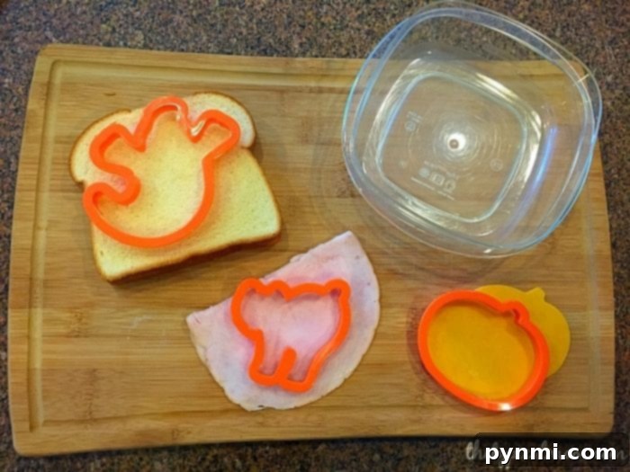 A child's lunchbox showcasing a deconstructed sandwich setup, featuring fun cut-out bread and cheese shapes, encouraging kids to build their own meal.