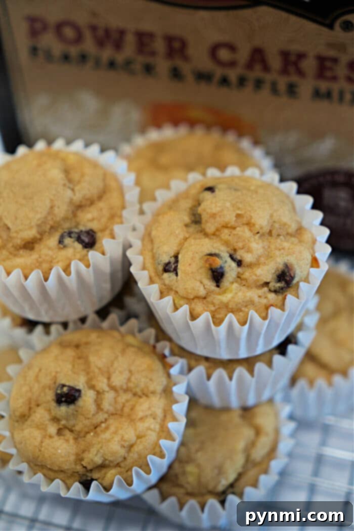 Wholesome Banana Power Muffins 5 A stack of Kodiak Muffins in white paper liners sits in front of a box of pancake mix, tempting you with every chocolate chip.