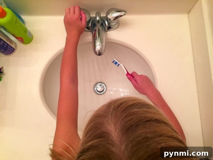 person turning off faucet while brushing teeth to save water