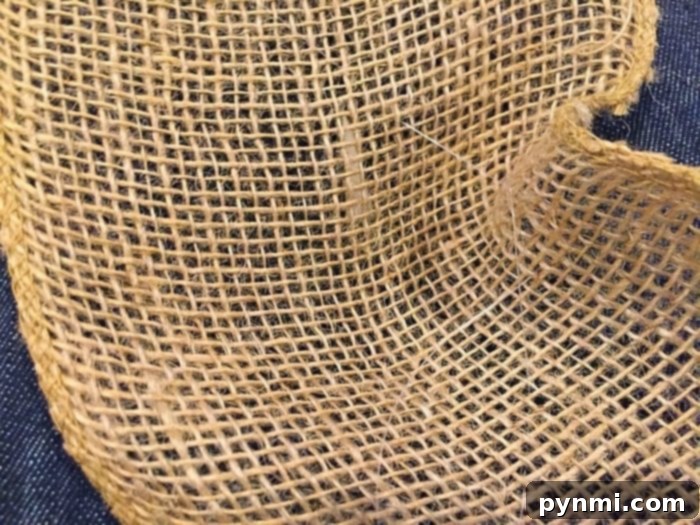 Zigzag Stitch Technique for Burlap Garland Detailed shot showing clear craft wire being stitched through burlap in a zigzag pattern, ready for gathering.