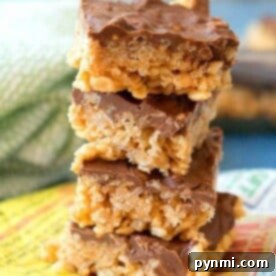 A delightful stack of chocolate-covered Rice Krispies treats sits on a colorful napkin, reminiscent of those irresistible Scotcheroos.
