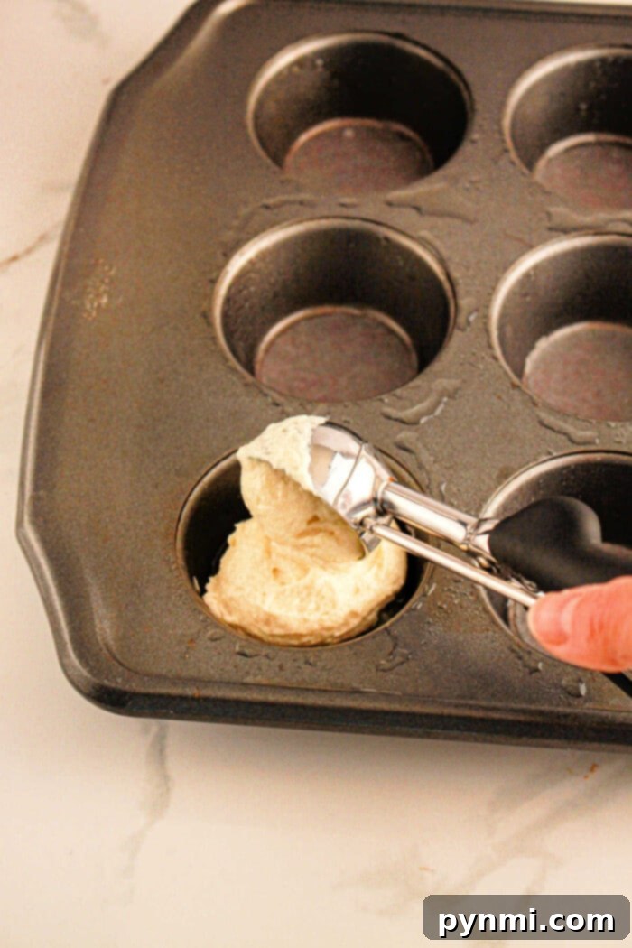 These muffin tin pineapple upside down cupcakes and really easy muffin tin desserts to make and the kids love them! Mini size cakes you can make using ingredients from the Dollar Store. If you love muffin tin recipes this is a fun one to try. #muffintin #dessert #pineappleupsidedown #cupcakes #cake A tray of freshly baked pineapple upside-down cupcakes in a muffin tin, garnished with cherries and ready to be served. The image title suggests these are easy, kid-friendly muffin tin desserts made with Dollar Store ingredients.
