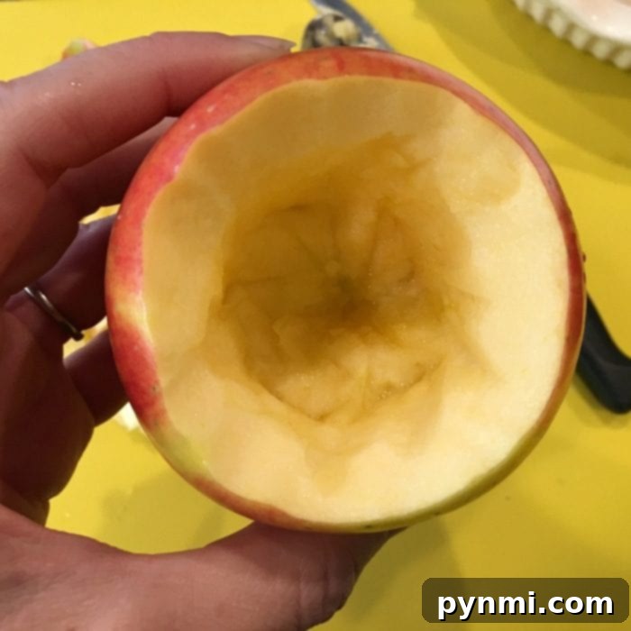 Whole apple stuffed with oats, brown sugar, and caramel bits, ready for baking, illustrating a healthy baked apple dessert.