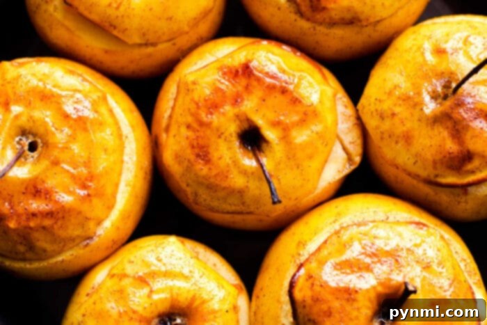 Close-up of baked apples in the oven, showing bubbling caramel and oats, illustrating the cooking process.