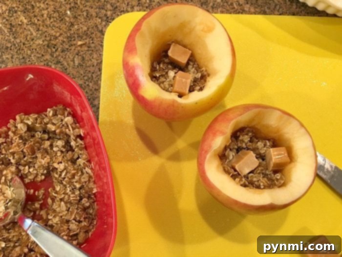 Two baked caramel apples served in a dish, garnished with a drizzle of caramel, a perfect warm apple dessert.
