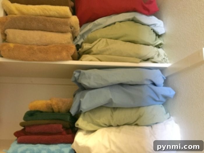 Neatly organized linen closet shelves after implementing the pillowcase method
