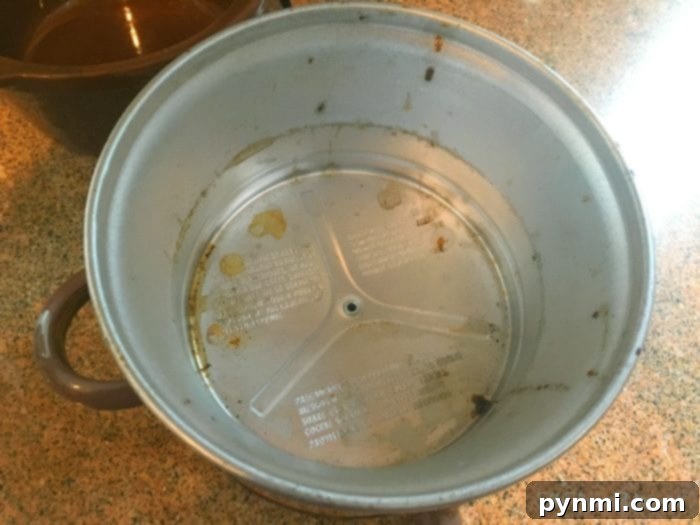 A detailed view of the stubborn grime accumulated within the slow cooker's heating unit, highlighting the need for effective cleaning. #CrockpotCare #KitchenCleaning Close-up of baked-on food residue and grease inside a slow cooker's heating element.