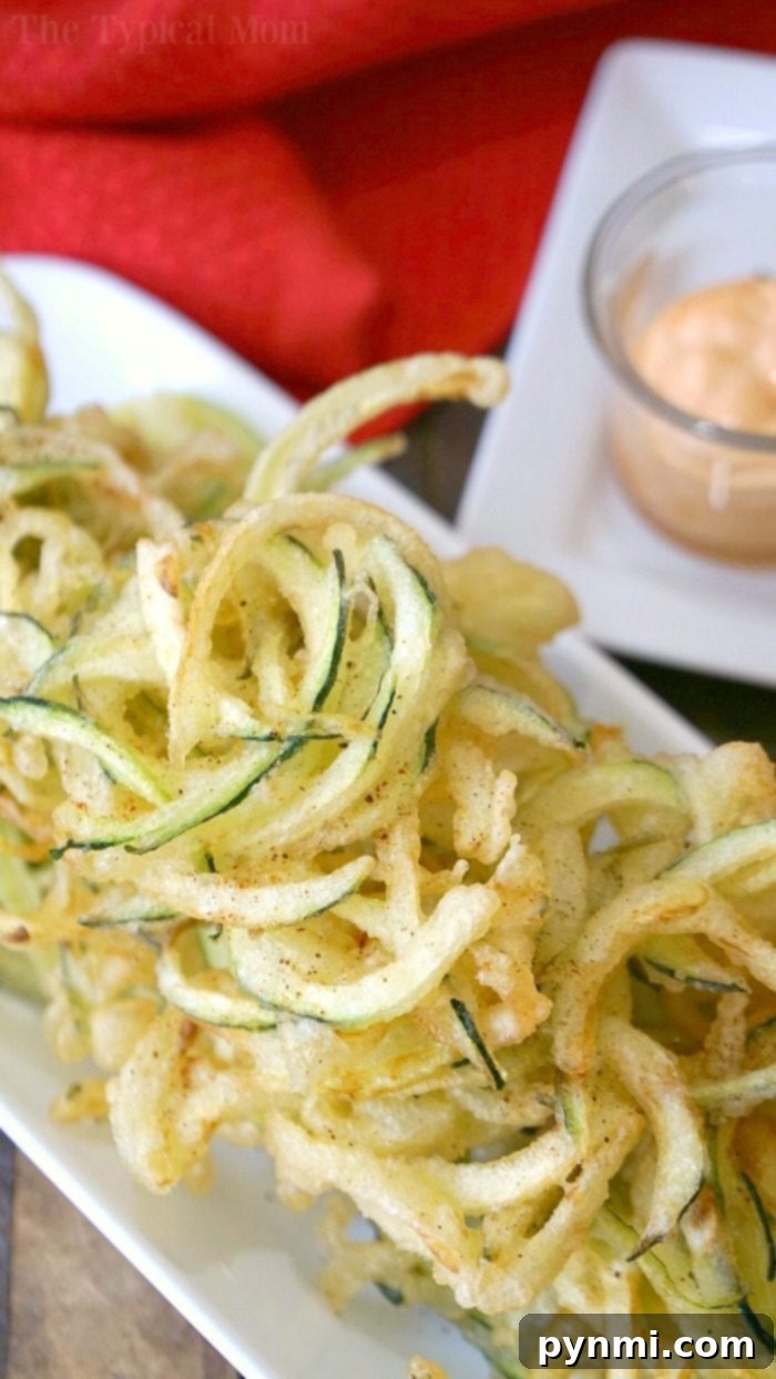 Spiralized salt and pepper zucchini chips with tempura batter offer a creative twist on this beloved snack or side dish. Spiralized tempura zucchini chips plated for serving, showcasing a unique presentation.