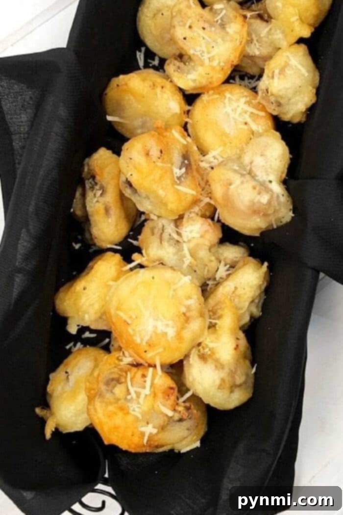 Golden-brown crispy fried mushrooms garnished with fresh herbs, a perfect appetizer