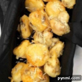Tempura mushrooms, delicately fried to perfection and garnished with a sprinkle of grated cheese, rest elegantly on a black cloth.