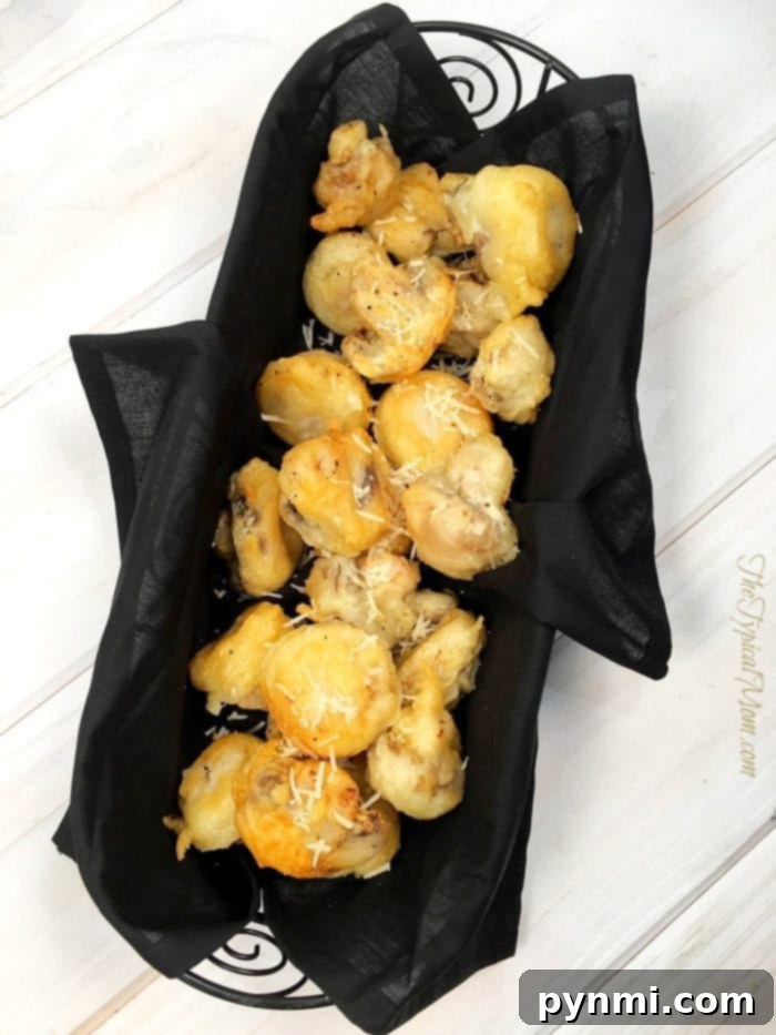 Parmesan rosemary mushrooms served hot on a plate, garnished with fresh herbs