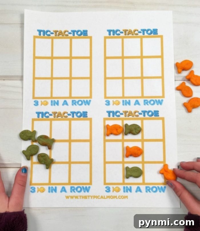 Goldfish crackers games like this fish tic tac toe game using different colors of Goldfish is fun to play! Great treats you can make with your kids as well as a game you can play with cheesy Goldfish crackers they all love! #freeprintable #printable #goldfish #games #tictactoe #game #fish goldfish game board with Goldfish crackers